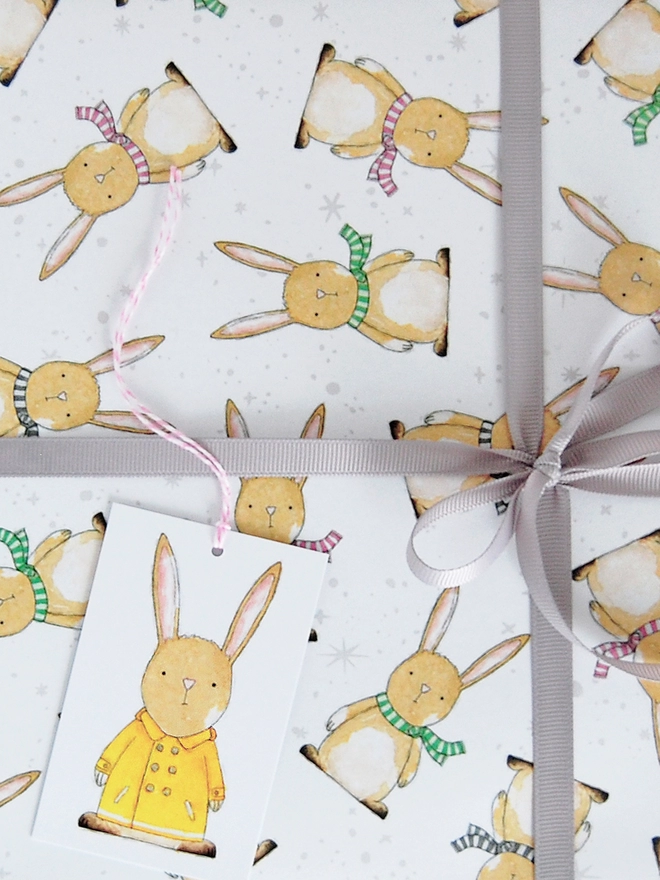 A new baby gift is wrapped is in wrapping paper with a baby rabbit design.
