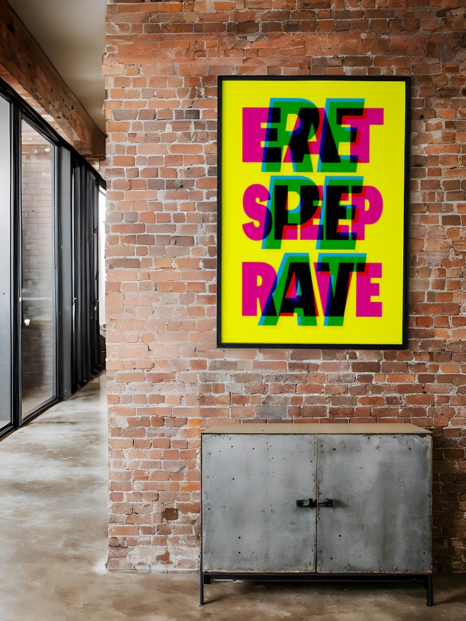 A colourful neon typographic giclée poster with the words "Eat Sleep Rave Repeat" hangs on a brick factory apartment. An ideal gift for an old raver!