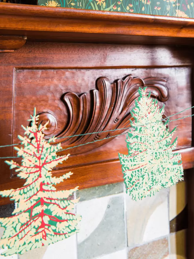 Close-up shots of evergreen trees in front of wooden fireplace