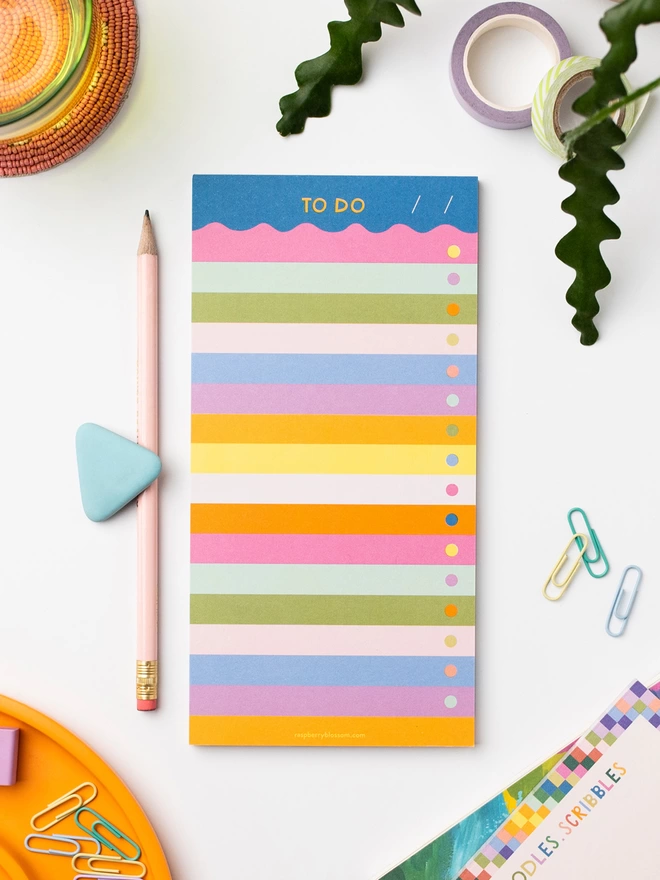 Raspberry Blossom wave 'To Do' list pad sits on desk with other colourful stationery items