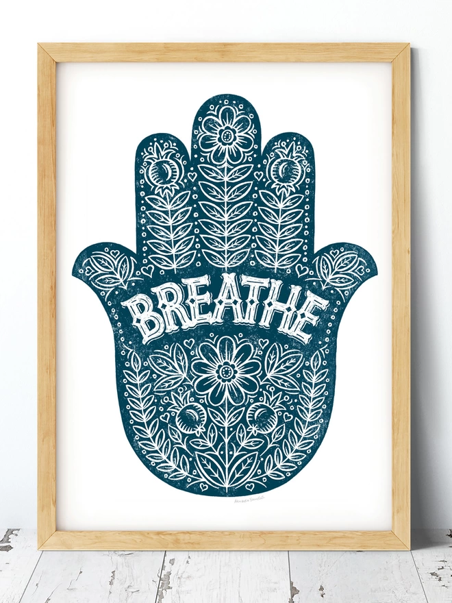 blue and white breathe yoga hand print in wood frame on white wash floor