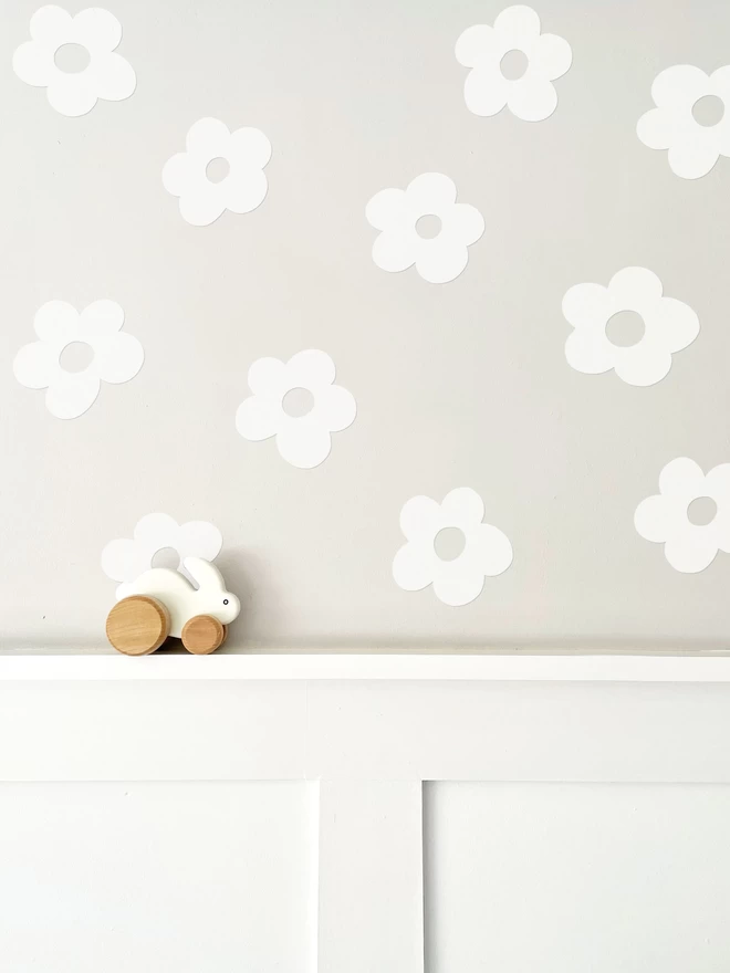 White flower wall stickers on Cornforth White above white wall panelling with wooden bunny toy