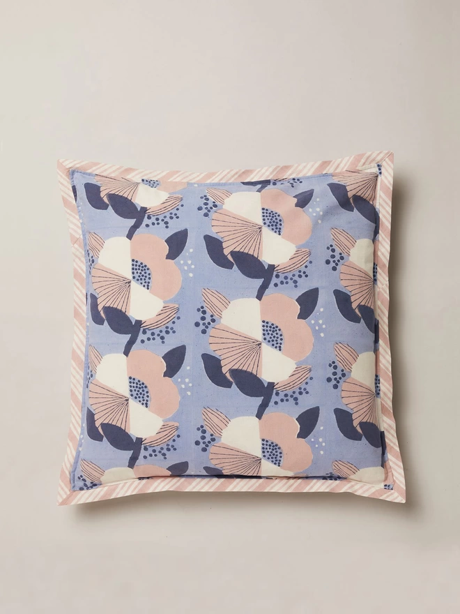 Block printed blue cushion featuring a large scale floral design in navy, cream and pink shades.