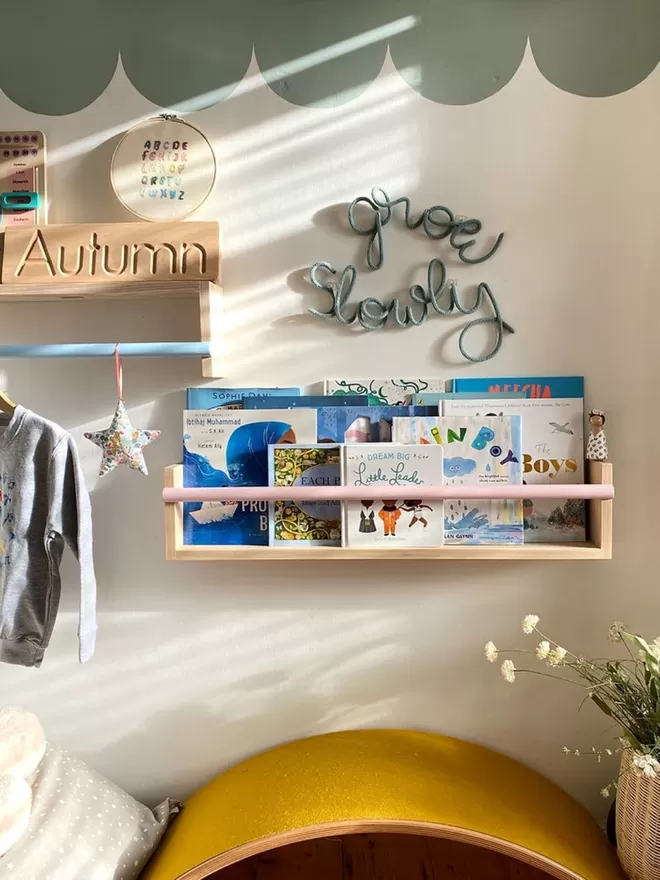 Beautiful kids bedroom with a large solid wood bookshelf, filled with kids books