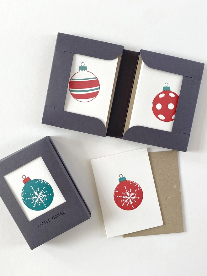 Open and closed gift boxes showing the spot, snowflake and four stripe designs in green and red