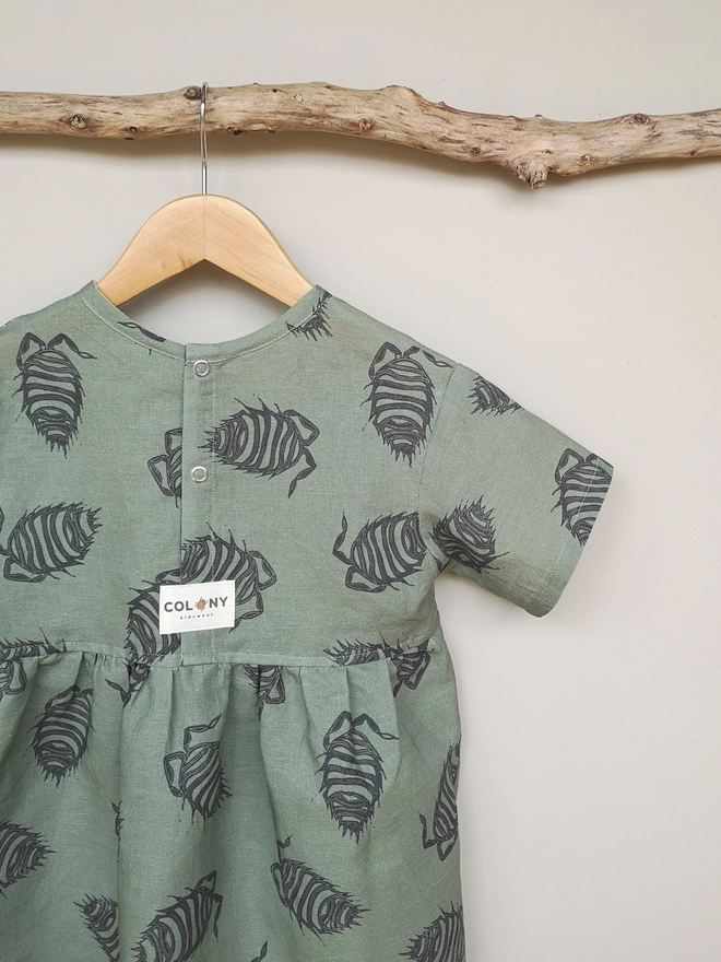 Cotton linen t shirt dress in a mossy green colour with a charcoal woodlouse print. Popper opening centre back and side seam pockets.