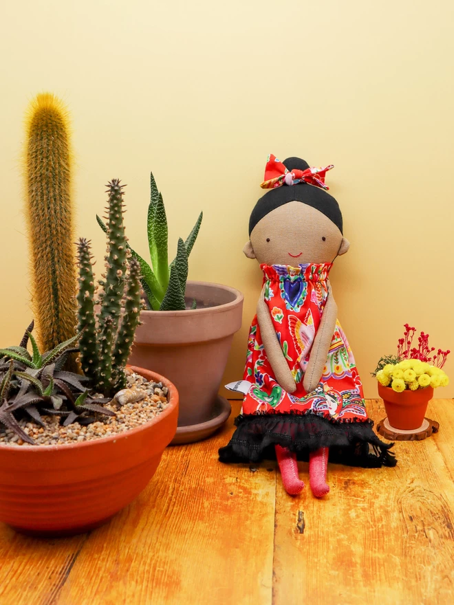 Mexican fabric doll wearing colourful dress and bow