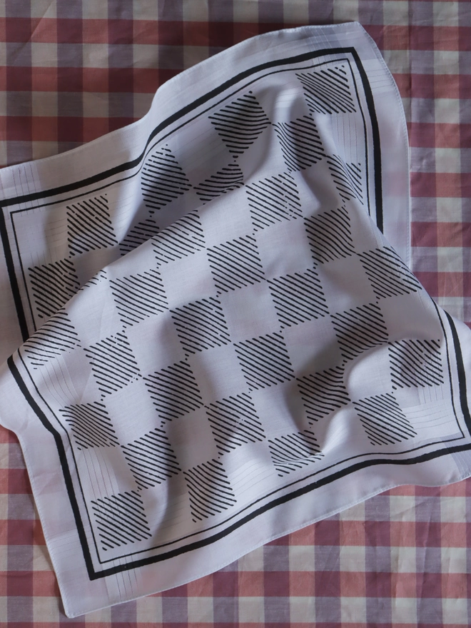 Mr.PS Checkerboard hankie in grey, on a pink gingham tablecloth