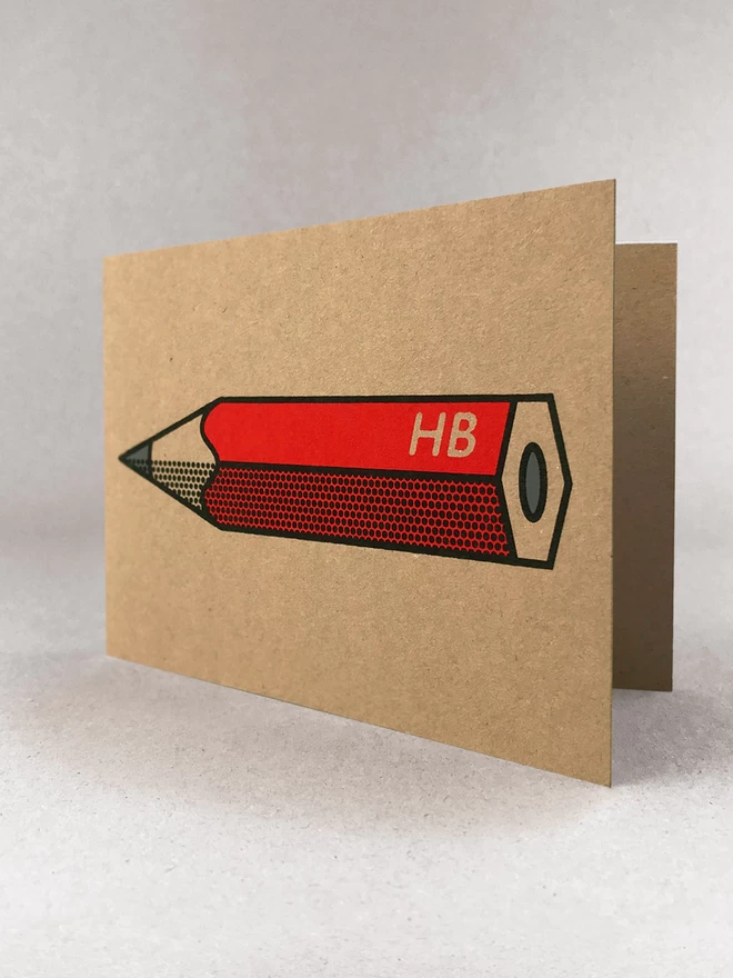 A red pencil design on brown Kraft card, with black outline and half tone detail. In a light grey background with soft shadows