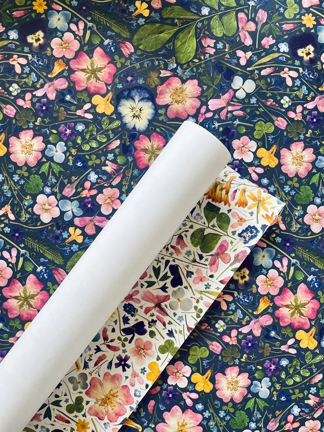 Rolled sheet of luxury floral wrapping paper in light and dark pressed flower designs