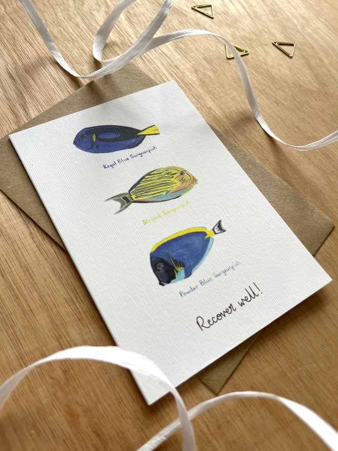 a greetings card featuring three surgeonfish and the phrase “Recover well!”