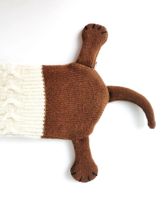 A close up of Dolly's back legs and tail showing the plain knit of her body next to the textured cable knit and rib of her coat.
