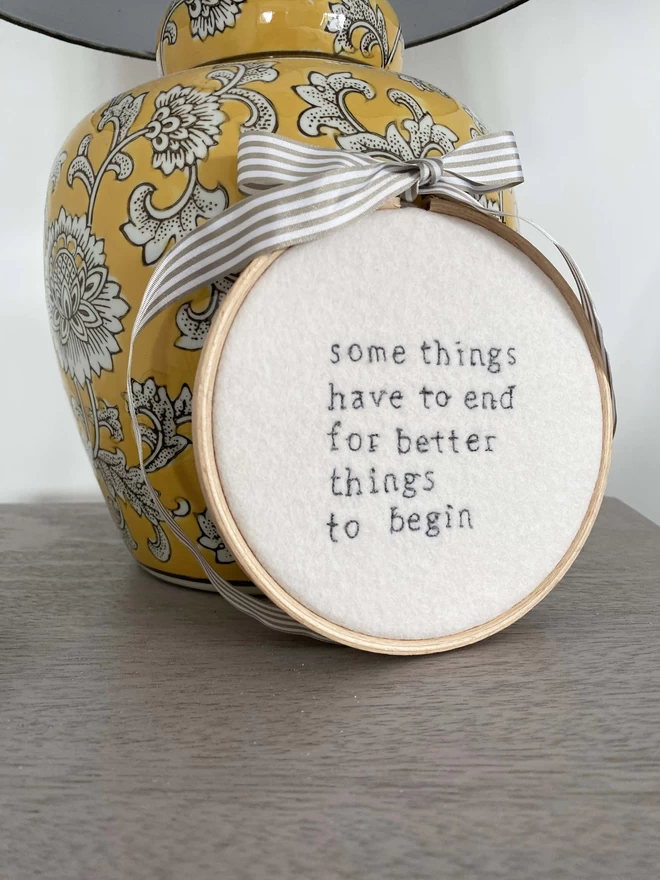Custom Quote Embroidery Hoop Decoration leaning on lamp on bedside table