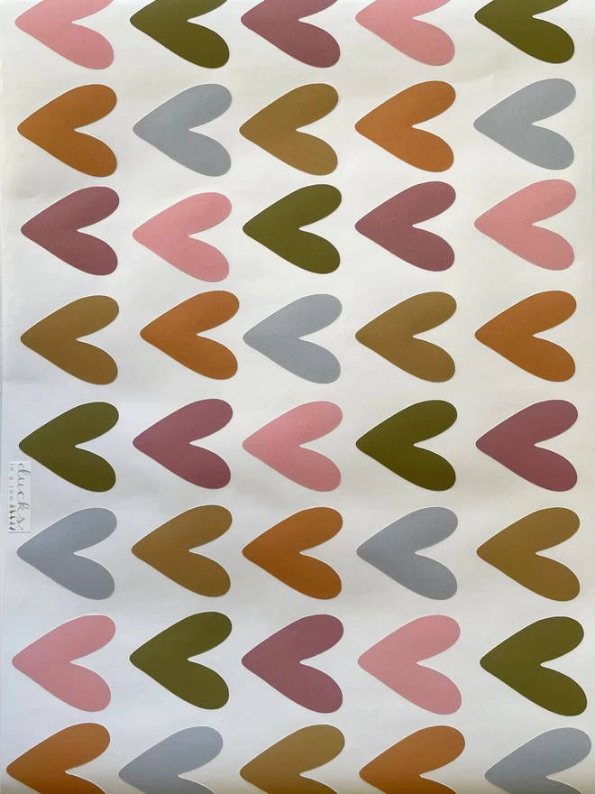 Photo of sheet of 48 muted rainbow coloured heart shaped wall stickers