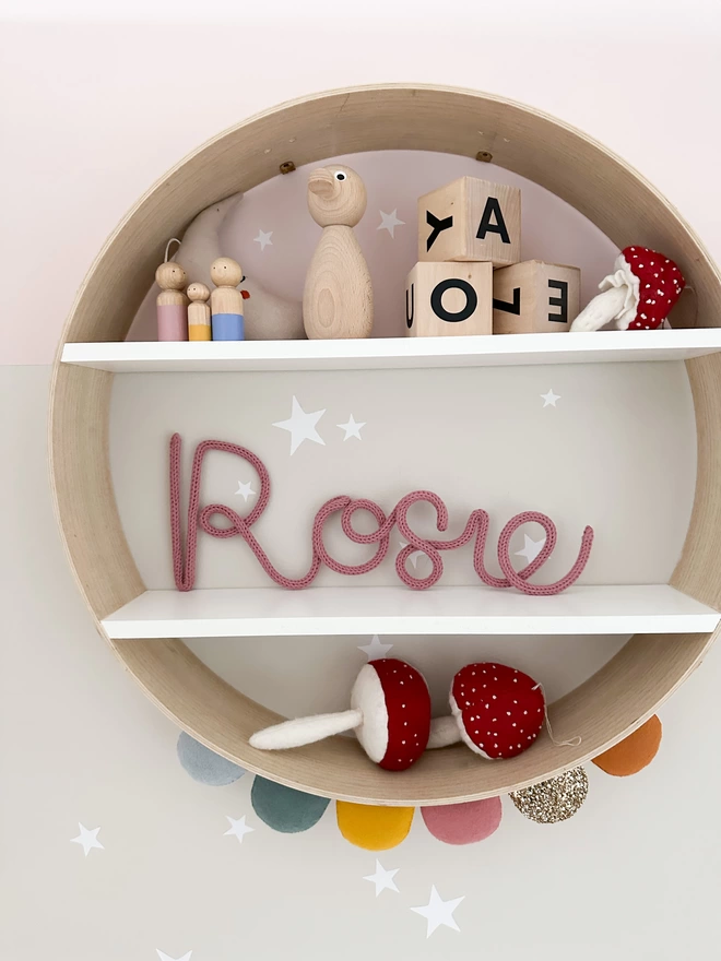 Custom wall name example - "Rosie" decorating a shelf in a babies nursery.