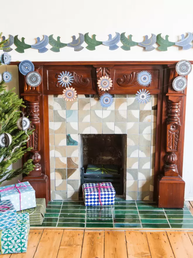 Full view of star garland and dove concertina garland hanging over fireplace