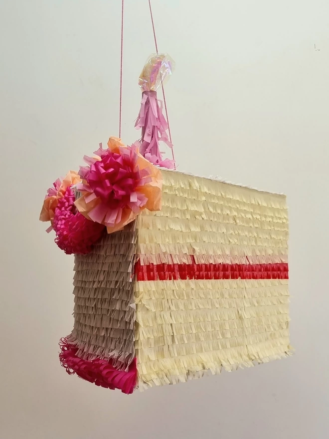 side view of the birthday cake pinata on a white background