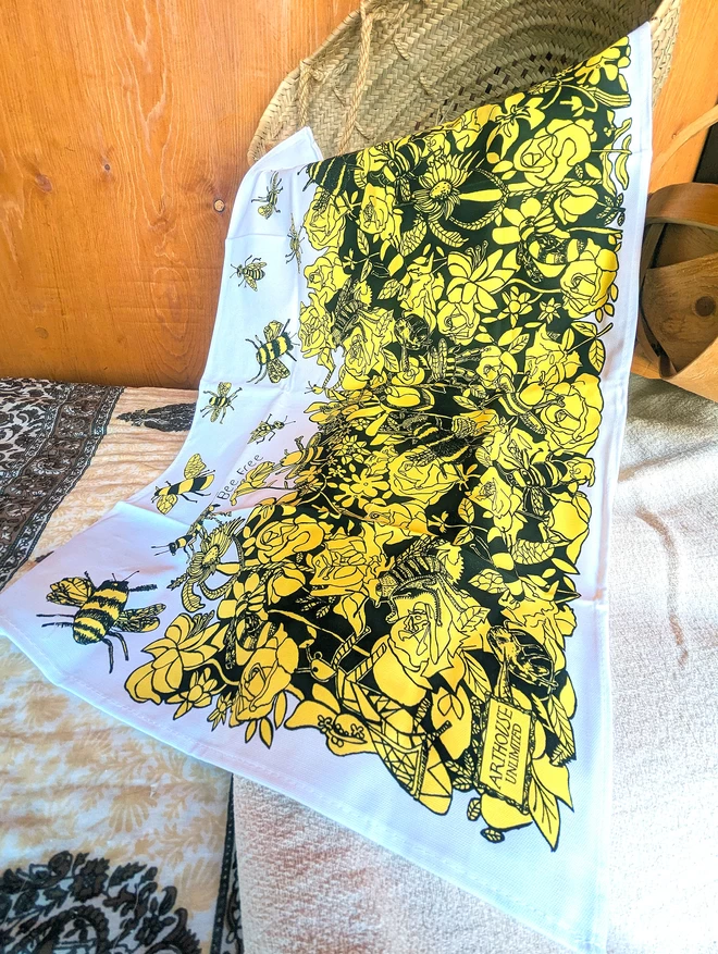 Close up of bee free 100% organic cotton yellow & black bee illustrated charity tea towel 