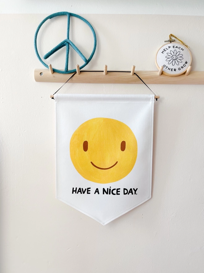 Yellow painted smiley face banner on a white background with the words have a nice day