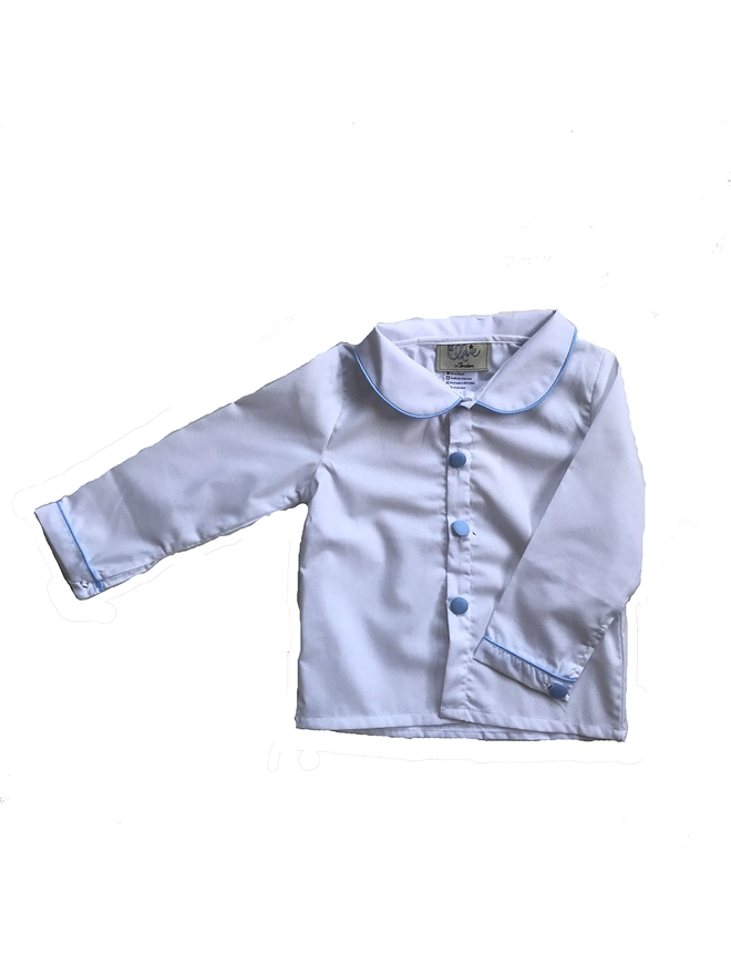 A white shirt with a peter pan collar and blue piping and covered buttons