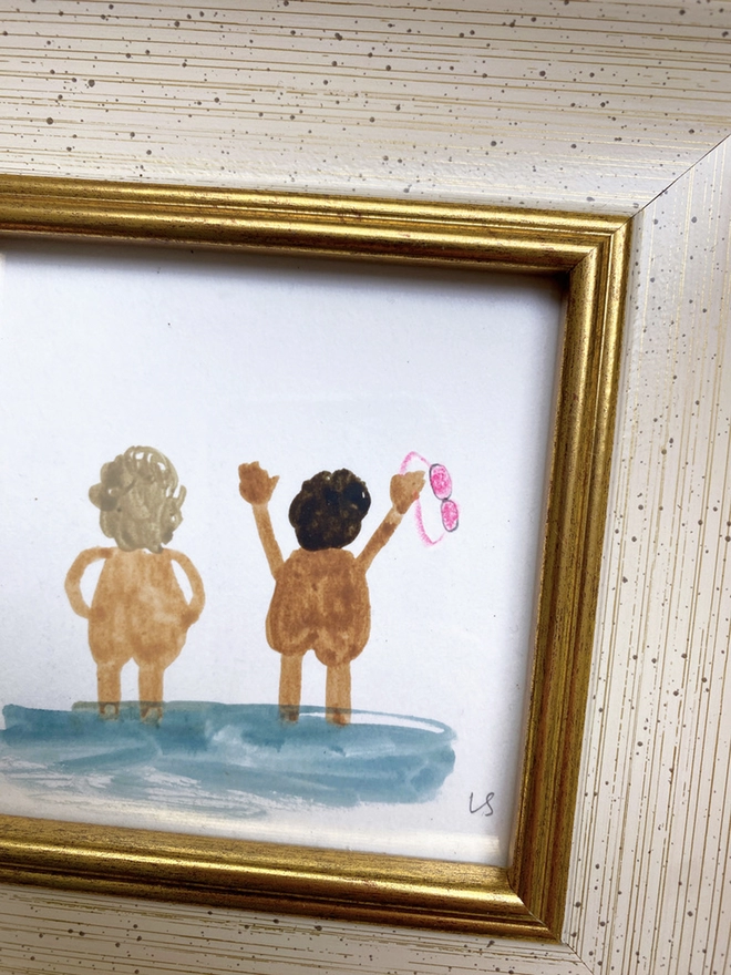 detail of framed picture of two naked people cheerfully looking out to sea with pink goggles