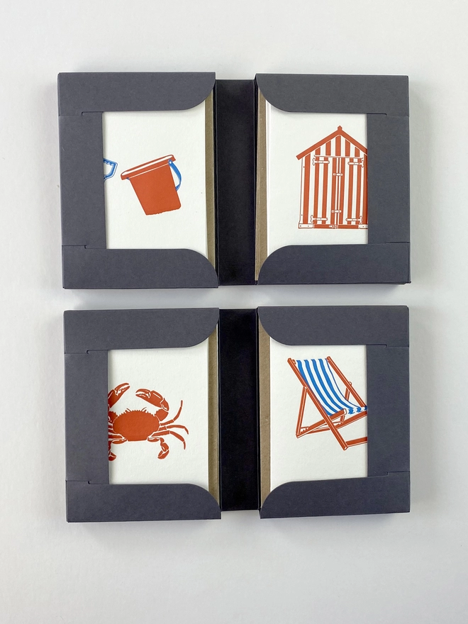 Two open beside the sea gift boxes showing the bucket and spade, beach hut, crab and deck chair little notes cards