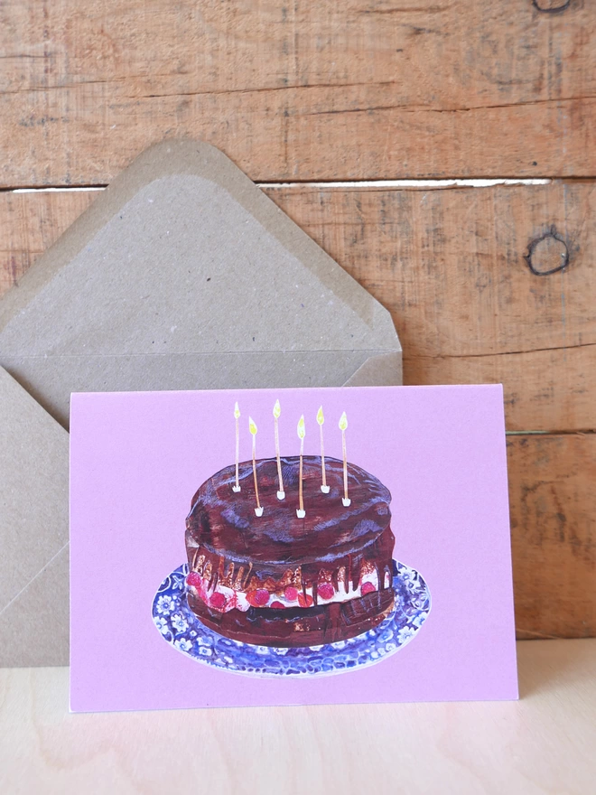 The front of the chocolate & raspberry birthday cake card with the brown kraft envelope next to it. 
