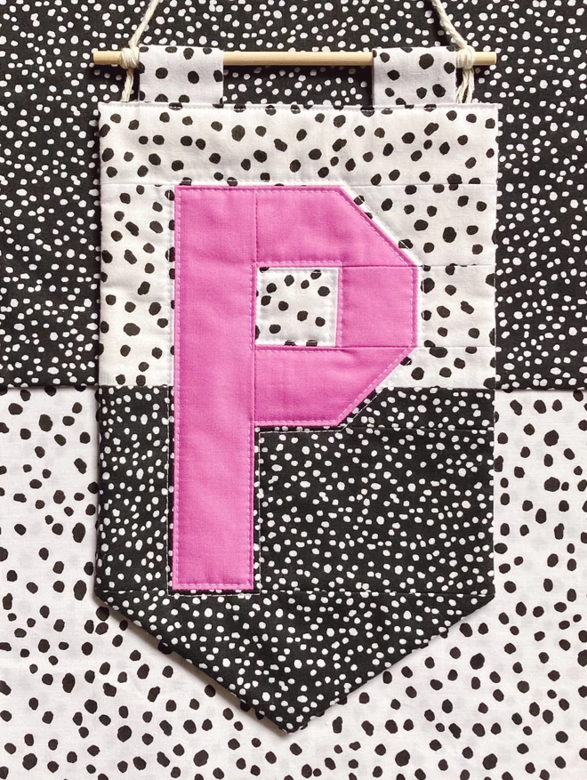 Cooper and Fred colour block quilted wall hanging with contrast spotty background and pink letter 'P'