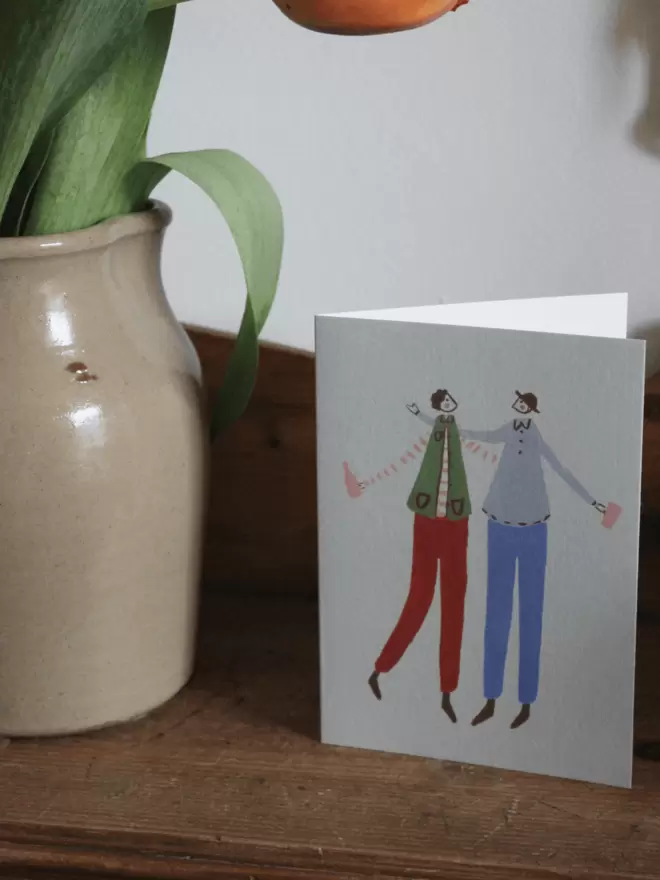 greetings card with 2 male best friends hugging and celebrating