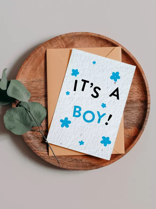 'It's A Boy' New Baby Plantable Card with Blue Flower Illustrations on a wooden tray next to eucalyptus