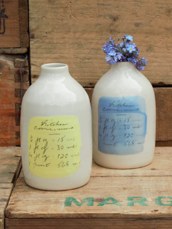 two handmade ceramic bottle vases with handwritten text of kitchen conversions