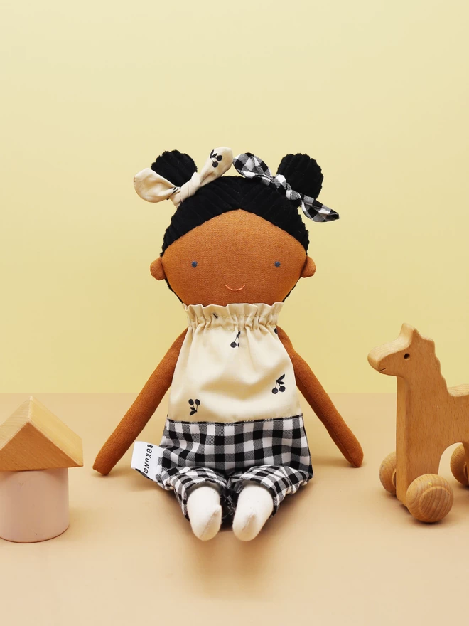 fabric girl doll with dark skin and gingham outfit 