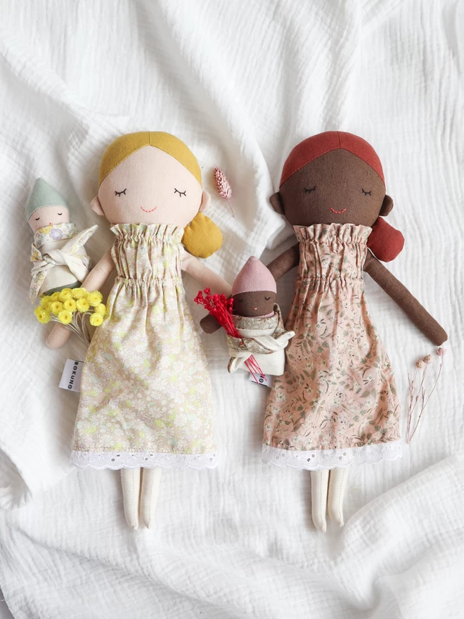 mother doll in floral dress and baby doll wrapped in floral fabric 