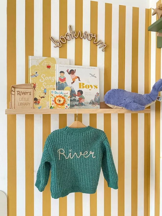A fun stripy yellow kids room. A beautiful solid wood book and picture ledge shelf is styled up with kids books, teddies and children's decor 