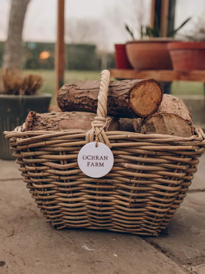 Wicker log basket with personalised ceramic tag filled with logs