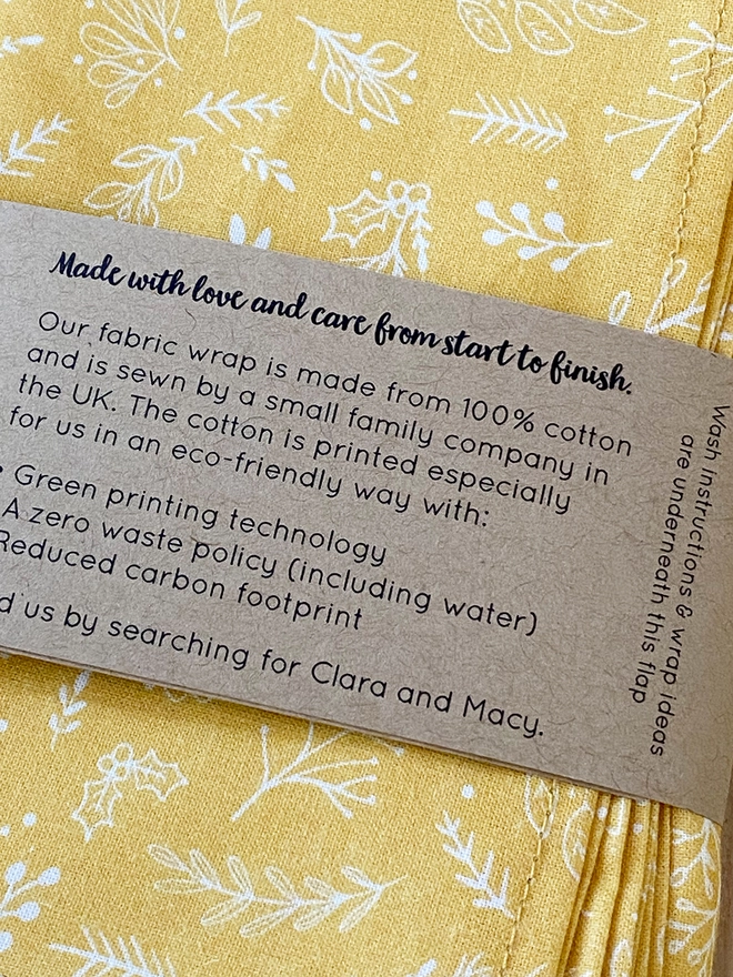 A mustard yellow cotton fabric wrap is folded with an instruction sleeve wrapped around it.