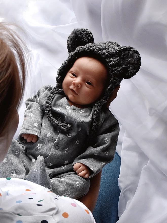 Baby smiling at mum, wearing handmade Koala hat