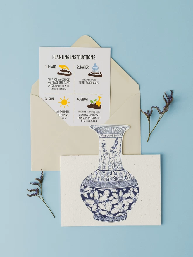 Ruby & Bo Plantable Dahlia Card on a white plinth amongst garniture of porcelain vases