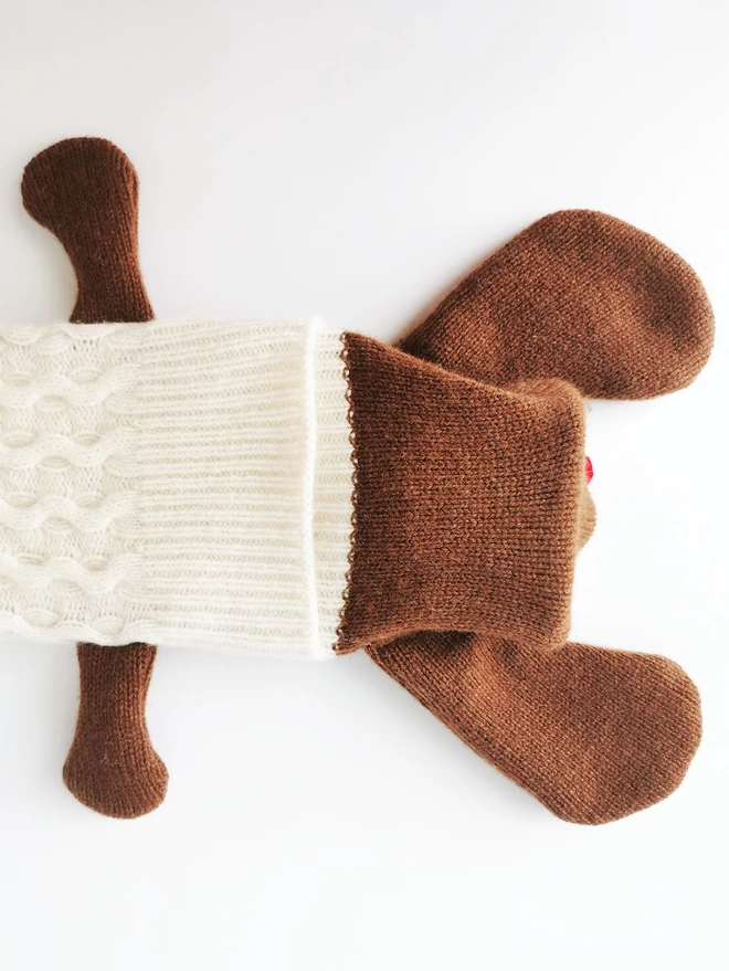 An image of the underside of Dolly's head, showing the knitted overlap that allows access to the hot water bottle inner.