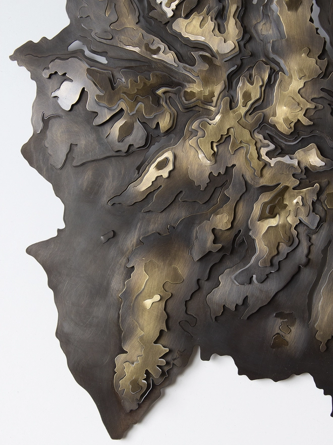 Close up of bottom left of the Lake District National Park blackened brass contour map.
