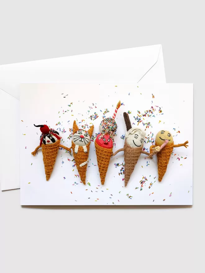 Kate Jenkins' Ice Cream Party Card seen with its white envelope behind. On the front of the card are Kate's crotched ice creams surrounded by sprinkles.