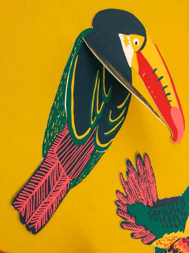 Close up of brightly coloured toucan on yellow background