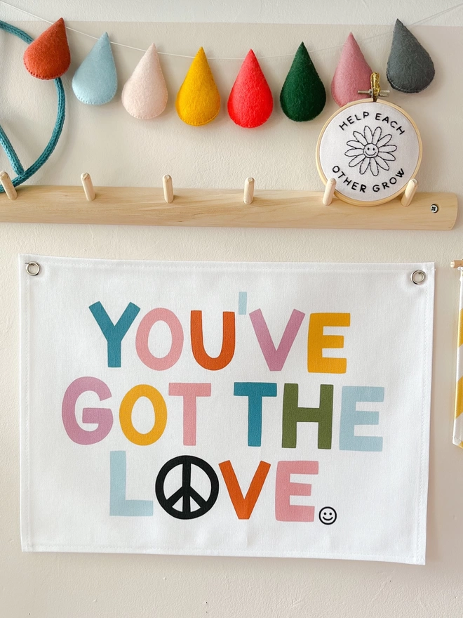 You’ve got the love wall hanging on a cream background wall