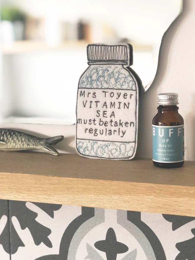 Vitamin Sea Personalised Medicine Bottle on a bathroom shelf with oil