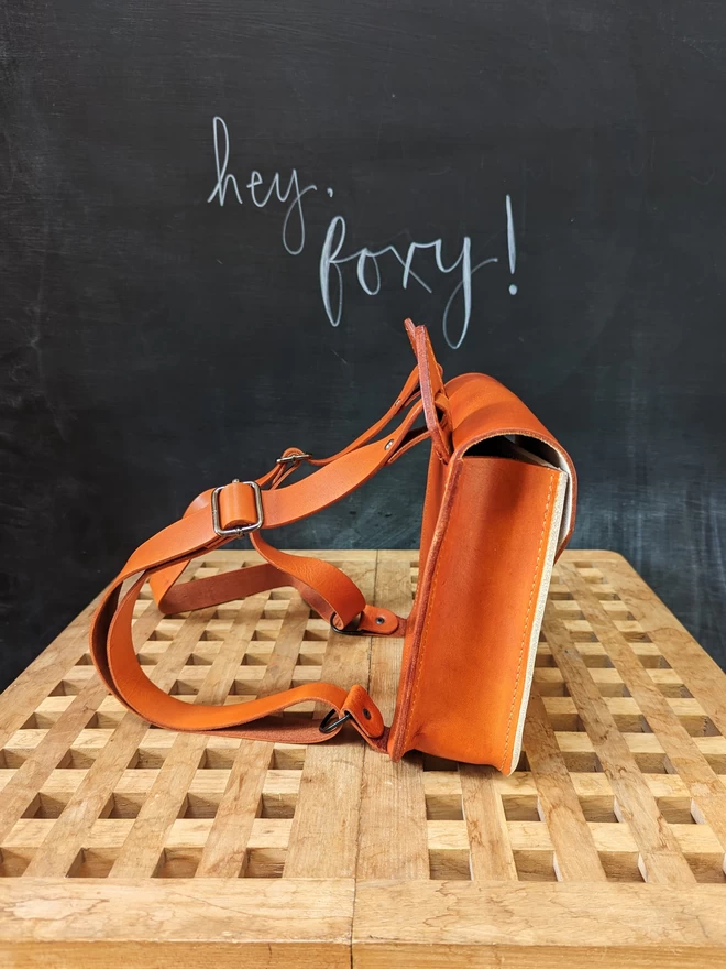 Side view of Orange and light tan leather fox backpack/