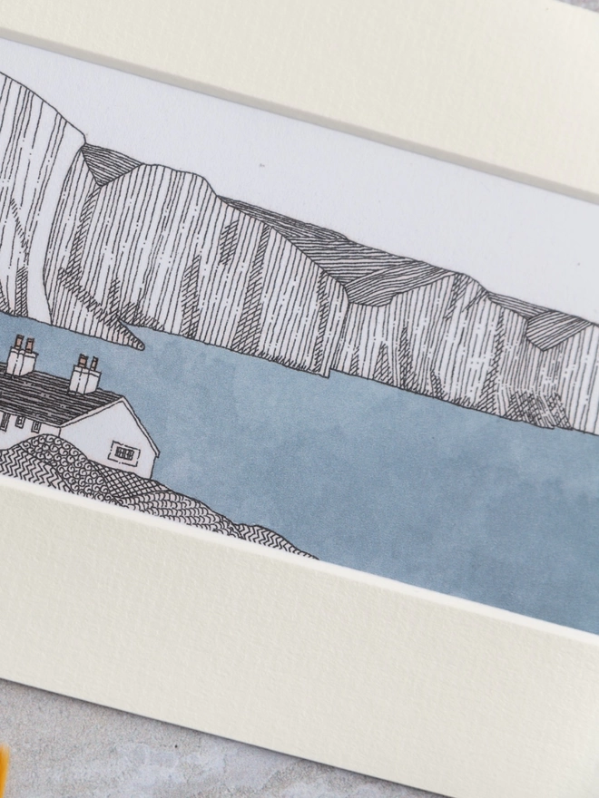 Print of a detailed pen and watercolour drawing of Seven Sisters cliffs, with cottage, in a soft white mount