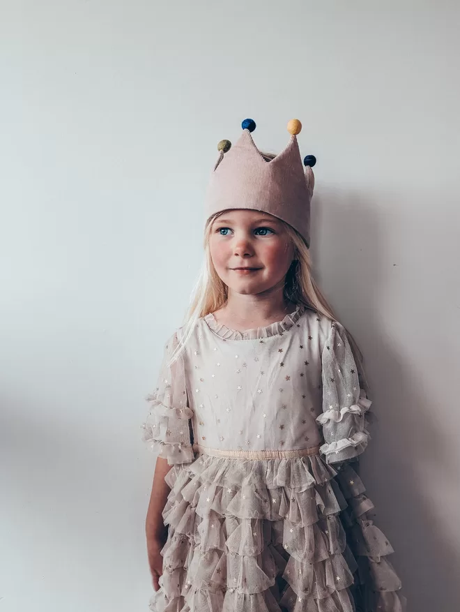 Girl wearing crown with pom poms