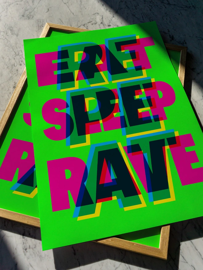 A colourful giclée typographic print with the words "Eat Sleep Rave Repeat" in bright pink, green, blue, and yellow, laid on a wooden frame against a marble surface. An ideal gift for an old raver!