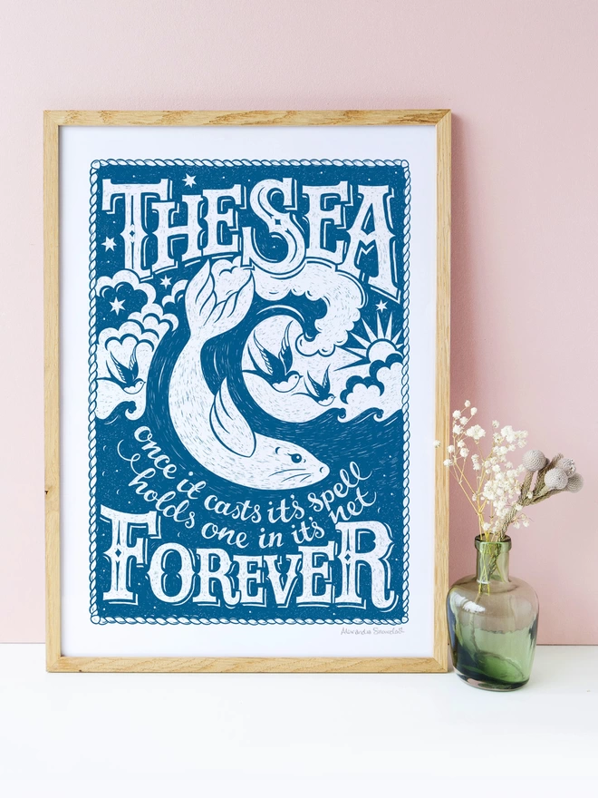 blue and white sea quote print with pink wall and green vase