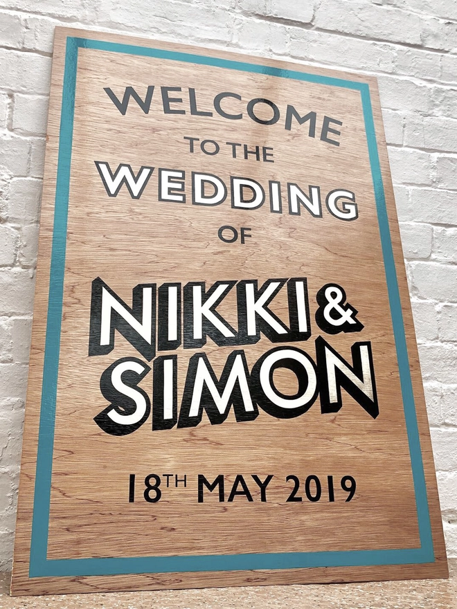 Welcome to the wedding sign with teal border and champagne gold